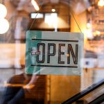 A sign on a store front that reads "Yes, we are open".