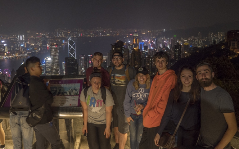students standing in front of a city