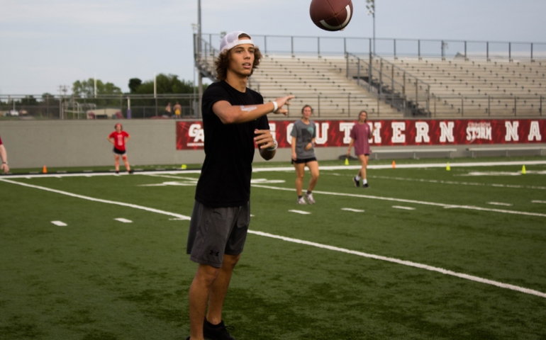 A student in the process of catching a football