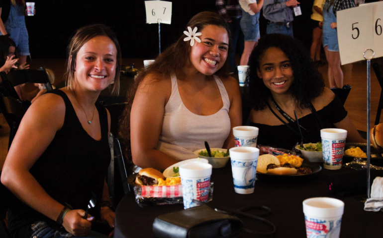 Three new students sitting and eating at Southern Supper