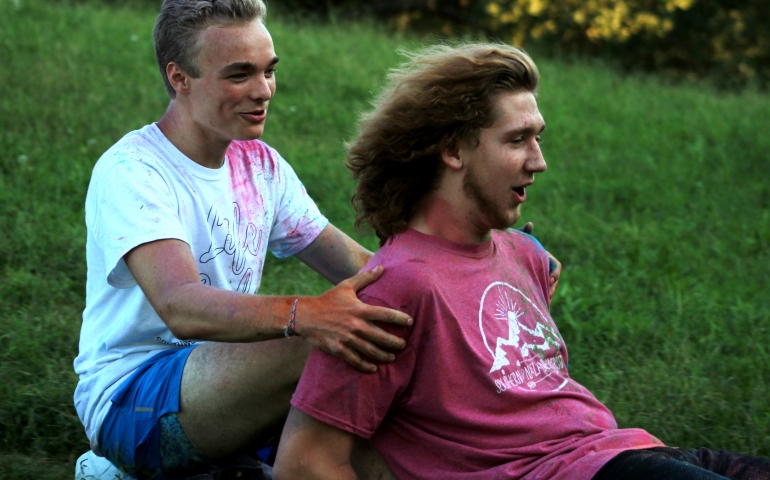 Two male students sliding down the hill on ice