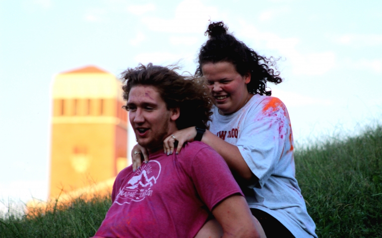 A male and a female student sliding down the hill on a block of ice together