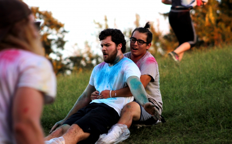 Two male students sliding on a block of ice together