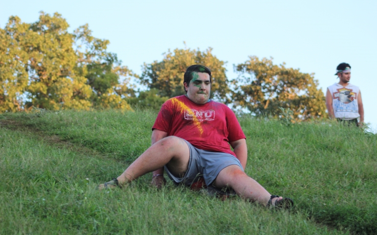 Noah Terry sliding down the hill on a block of ice, struggling