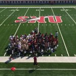 Crimson Storm football team huddled on the football field