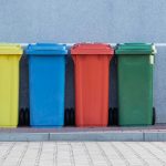 Multi-colored recycling bins on the side of the road