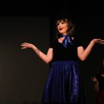 A woman questioning "what" with her arms