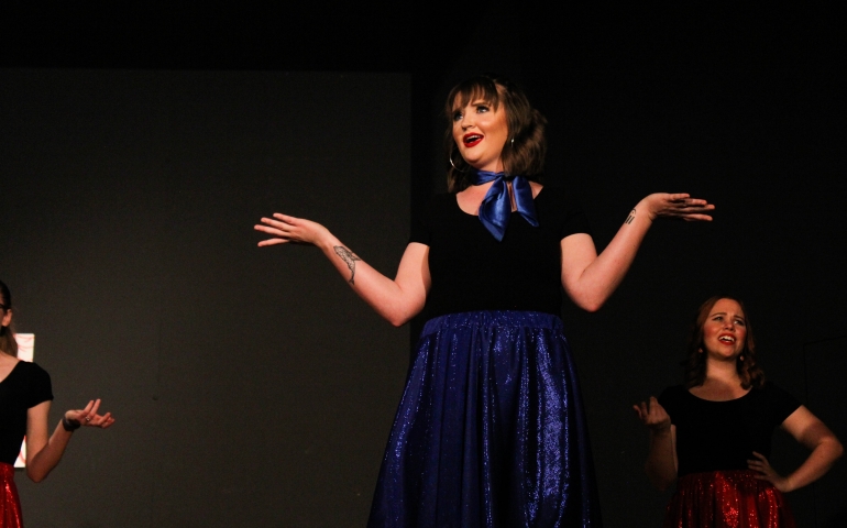 A woman questioning "what" with her arms