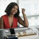 Main character at her office desk