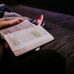 Student reading bible on couch