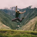 Woman jumping on a hike in the mountains