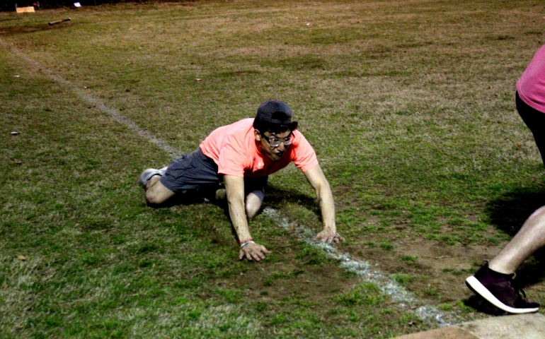 A student sliding into a base