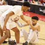 An injured player being helped up by his teammates